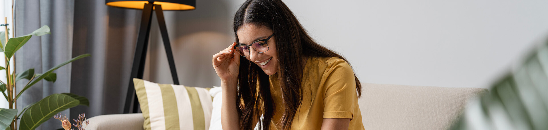 Junge Frau lachend vor einem Laptop