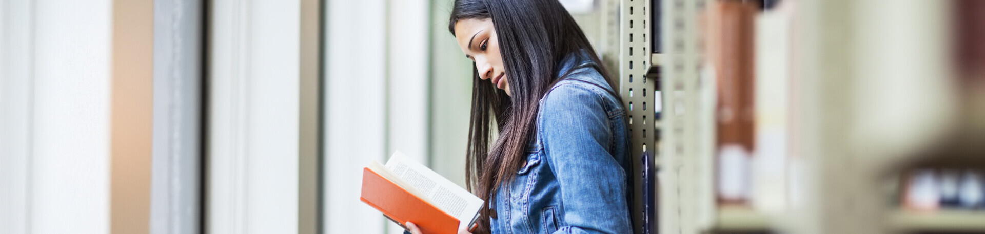 Frau schaut konzentriert in ein Buch