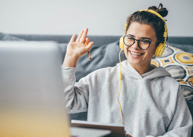 Lachende Studentin in einem Online Meeting