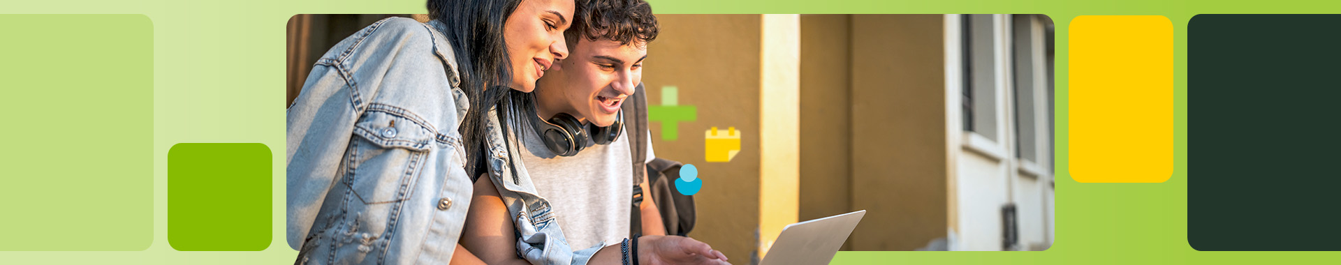 Junger Mann und junge Frau schauen gemeinsam lachend auf einen Laptop.