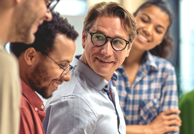 lachender älterer Mann mit jungen Studenten