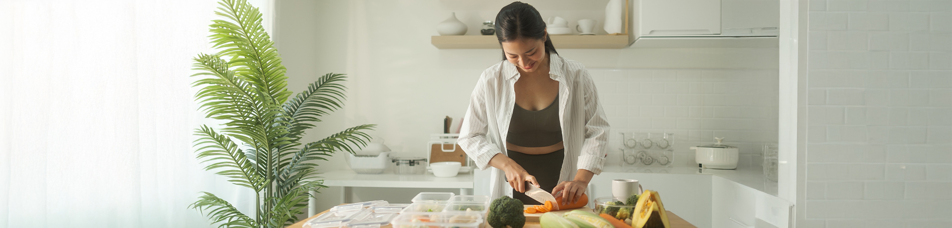 Junge Frau schneidet Gemüse auf einem Schneidebrett