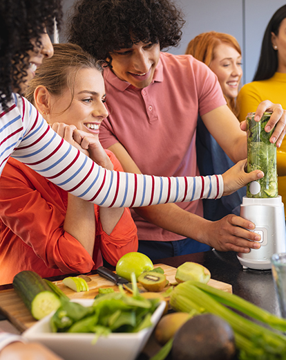 Freunde und Freundinnen bereiten in der Küche Getränke zu