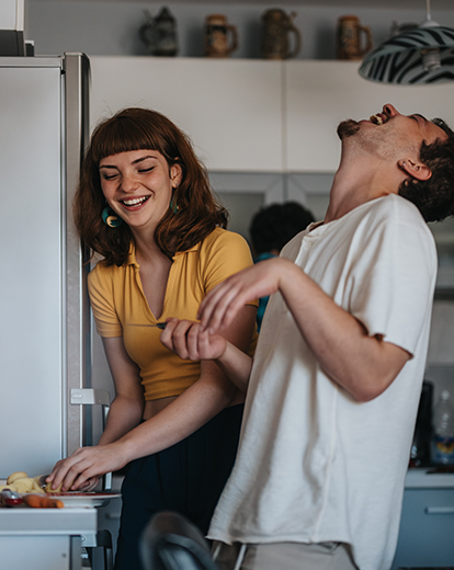 Junge Frau und junger Mann haben Spaß beim gemeinsamen Kochen.