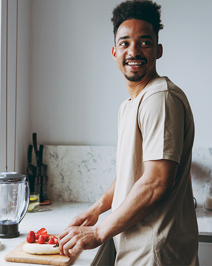 Mann schneidet glücklich eine Banane