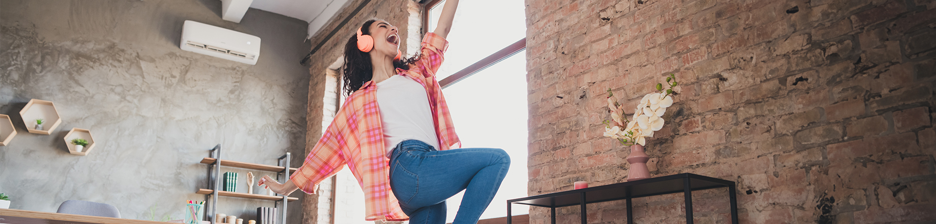 Junge Frau mit Kopfhörern tanzt fröhlich