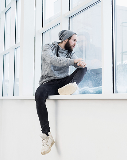 Mann schaut betrübt aus dem Fenster