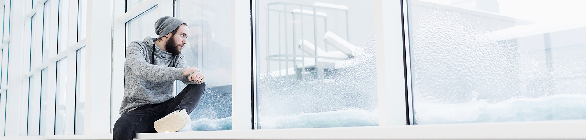 Mann schaut betrübt aus dem Fenster