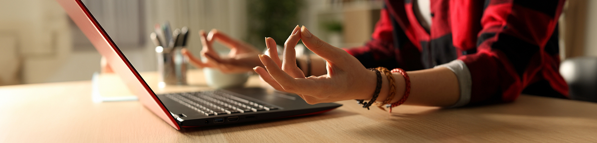 Frau sitzt meditierend vor dem Laptop