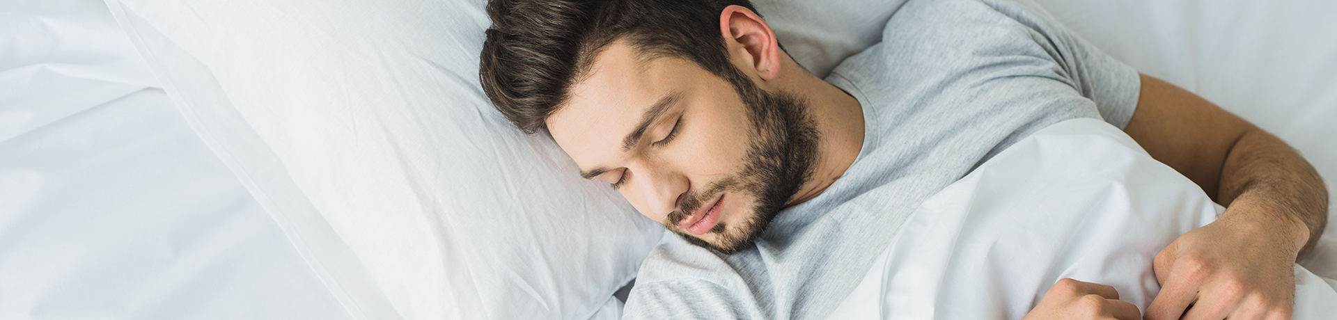 Mann liegt im Bett und schläft