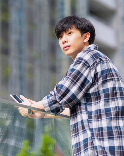 Junger Mann schaut von seinem Smartphone auf