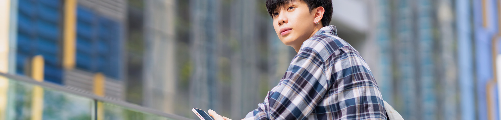 Junger Mann schaut von seinem Smartphone auf