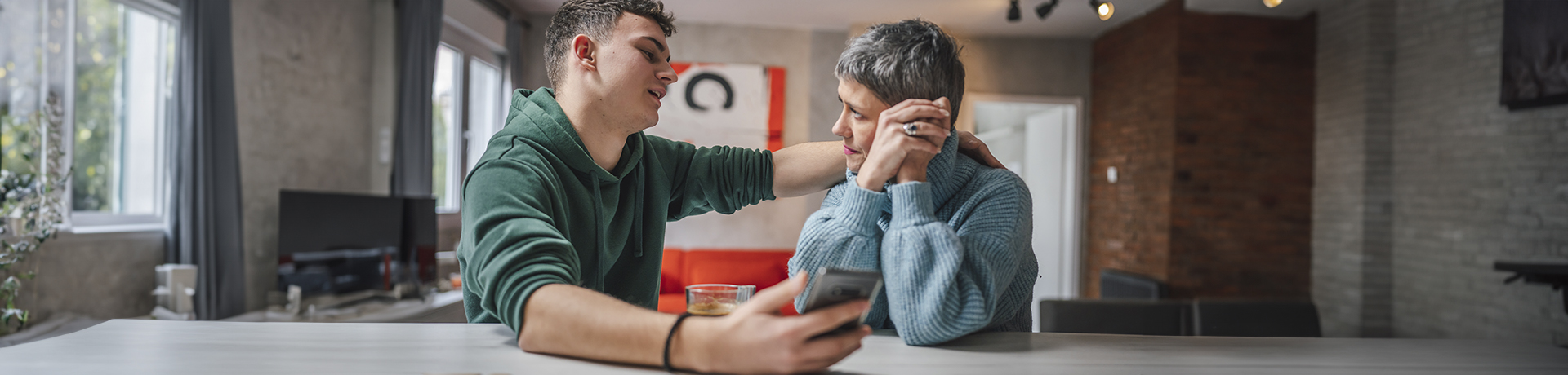 Junger Mann spricht mit älterer Frau