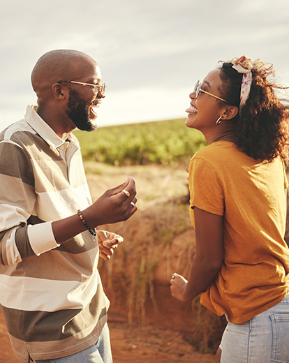 Ein Mann und eine Frau lachend auf einem Feldweg
