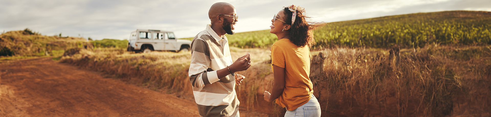 Ein Mann und eine Frau lachend auf einem Feldweg
