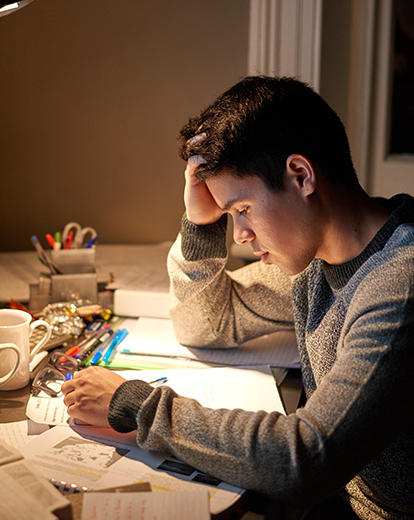 Student sitzt angestrengt vor seinen Lernunterlagen