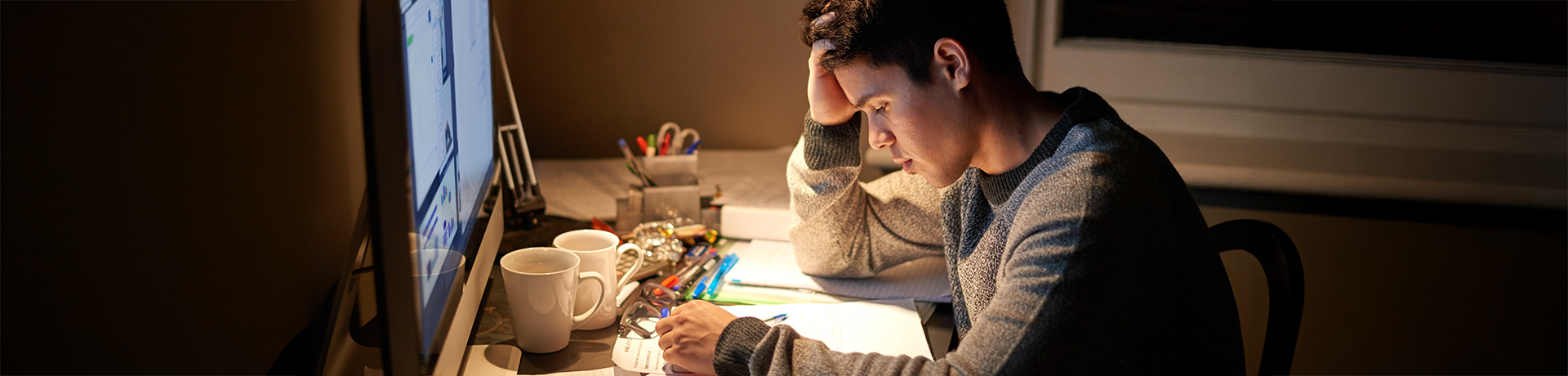 Student sitzt angestrengt vor seinen Lernunterlagen