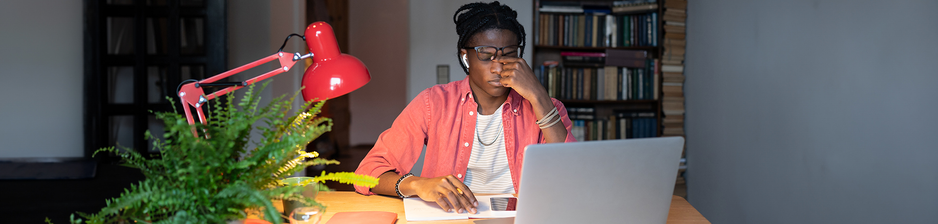 Mann sitzt vor Laptop und reibt sich die Augen