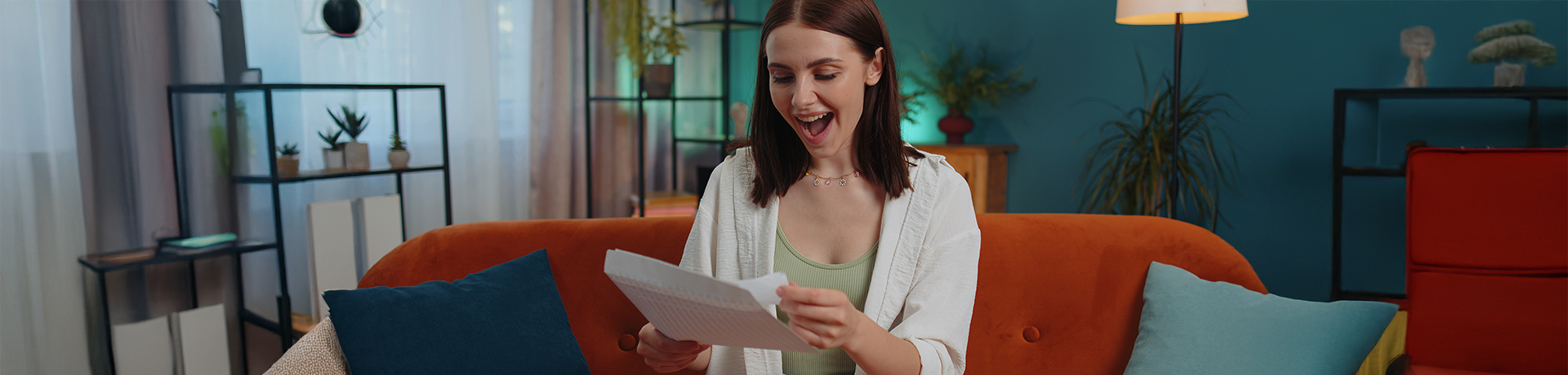 Junge Frau liest glücklich geöffneten Brief