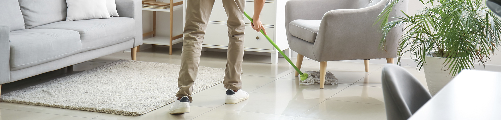 Person wischt mit einem Wischmop den Boden
