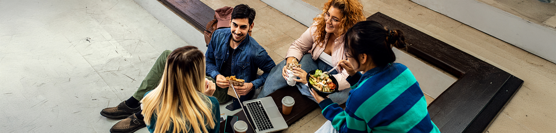 Gruppe an Studenten im Kreis beim Mittagessen
