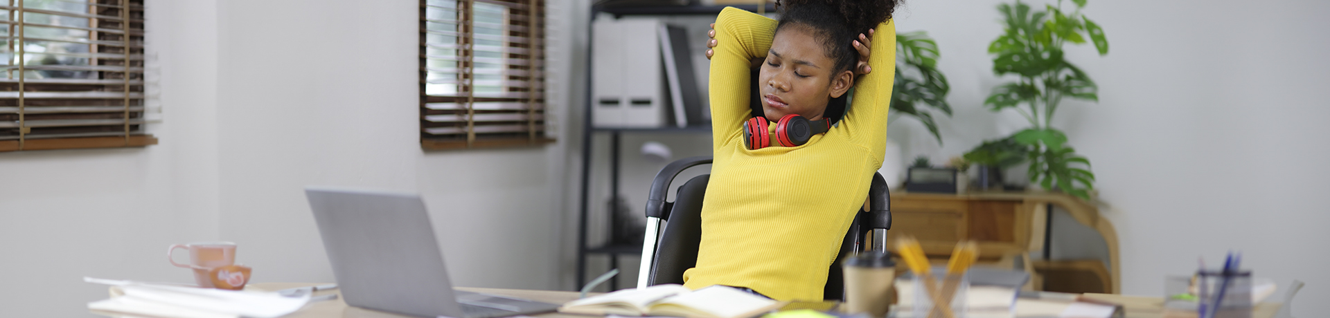 Studentin lehnt sich müde in einem Schreibtischstuhl nach hinten