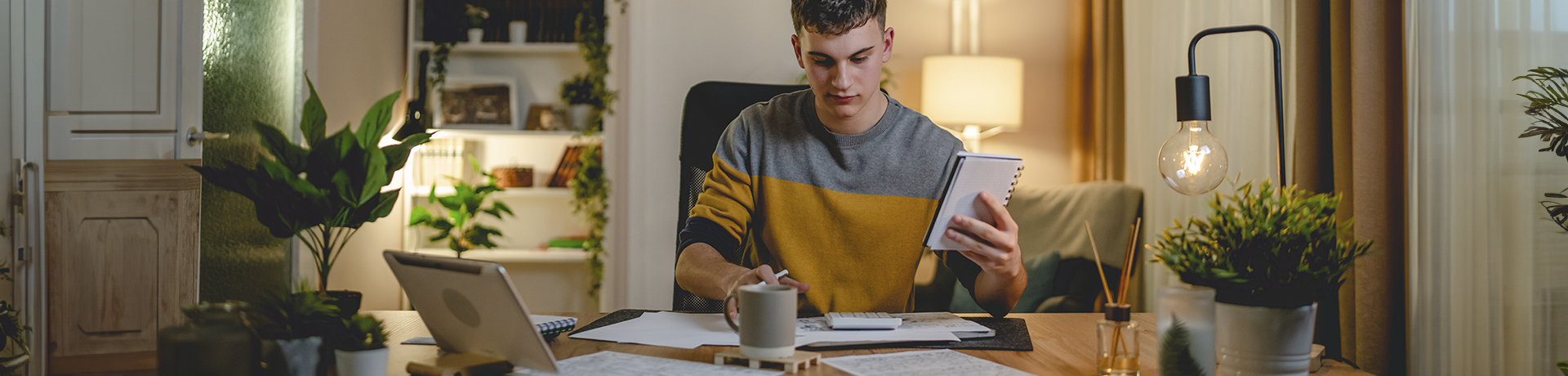 Student sitzt an einem Schreibtisch vor Papieren