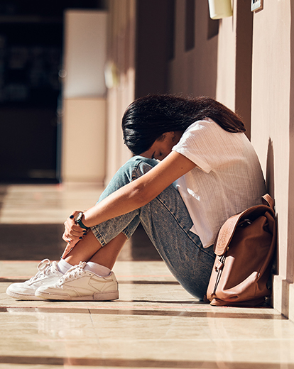 Junge Frau zusammengekauert auf dem Boden