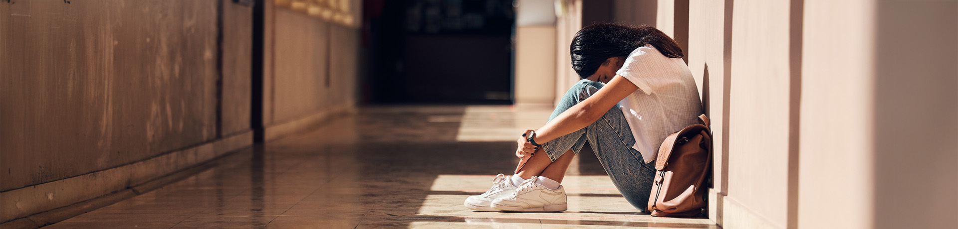 Junge Frau zusammengekauert auf dem Boden
