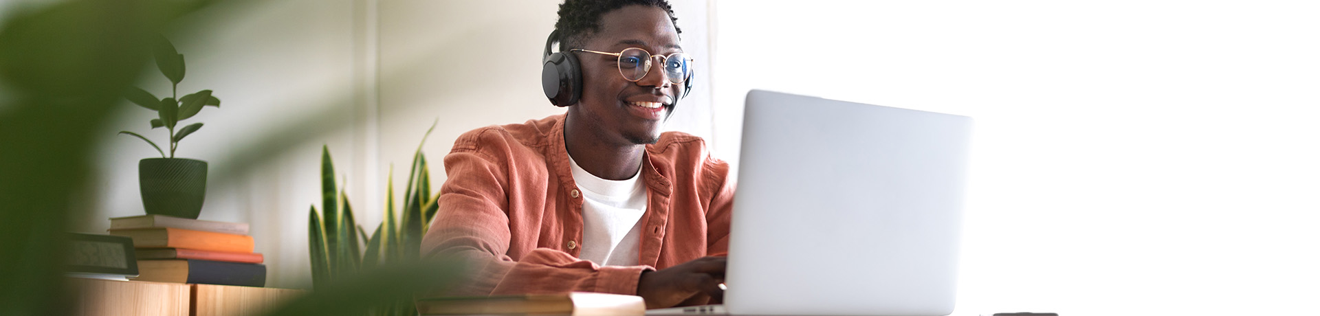 Mann sitzt vor einem Laptop und lacht