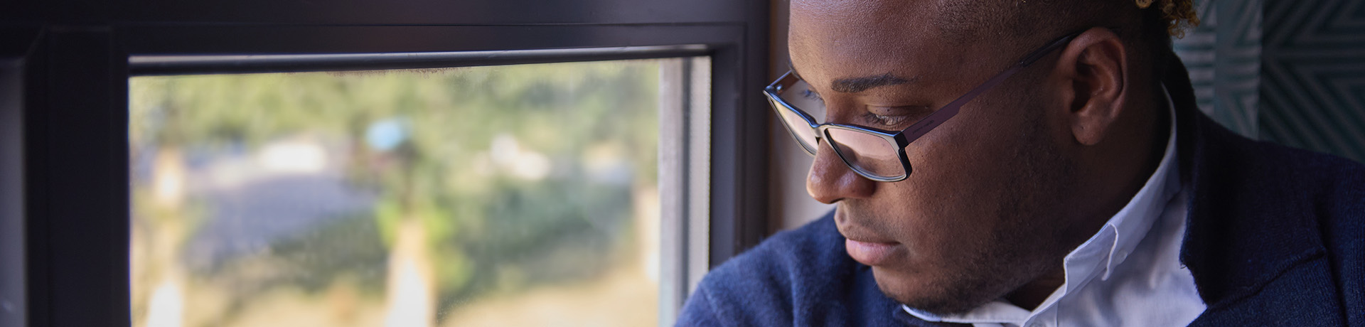 Mann schaut deprimiert aus dem Fenster