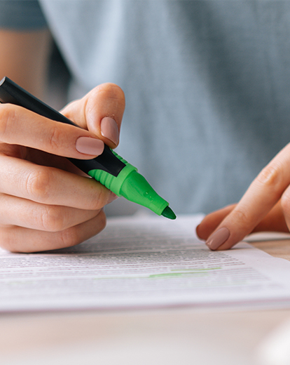 Person markiert Text mit grünem Filzstift