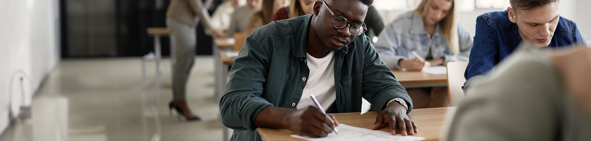 Student in einer Prüfung schreibt auf ein Blatt