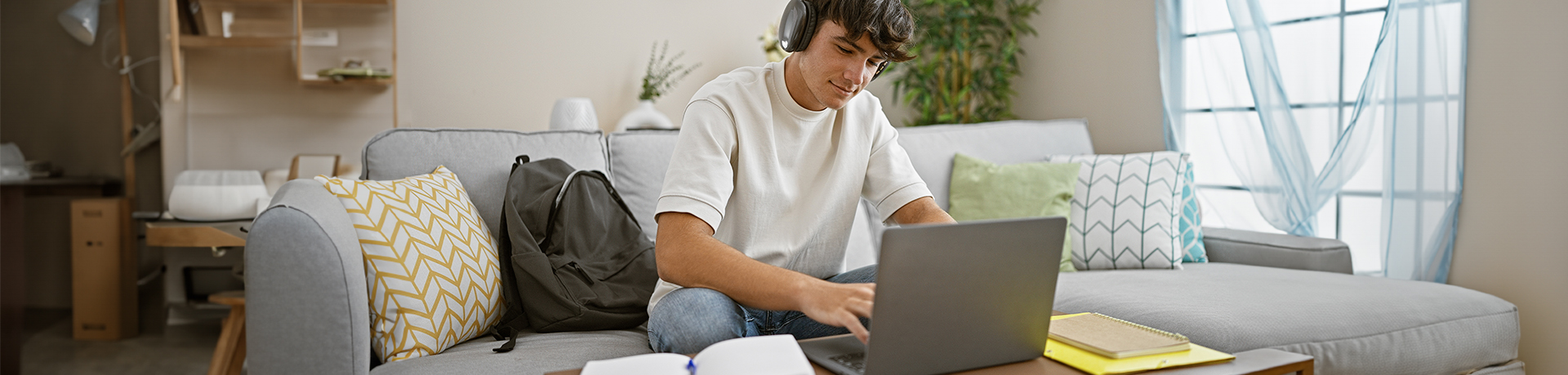 Junger Mann zufrieden vor einem Laptop