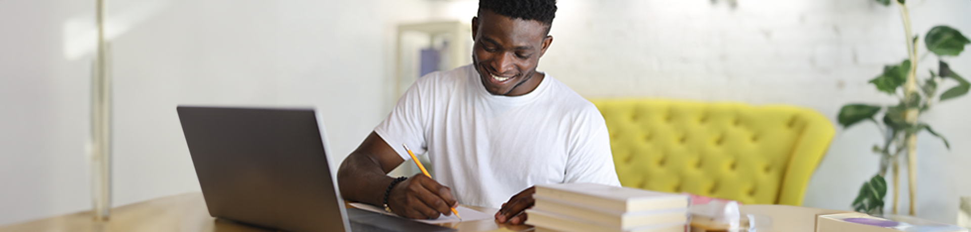 Student lächelnd schreibt auf Papier