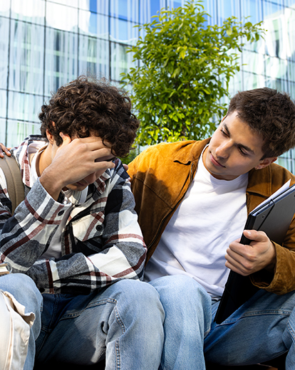 Ein junger Mann und eine junge Frau trösten einen traurigen Mann