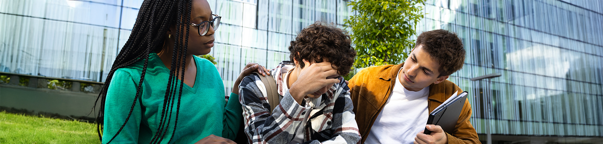 Ein junger Mann und eine junge Frau trösten einen traurigen Mann
