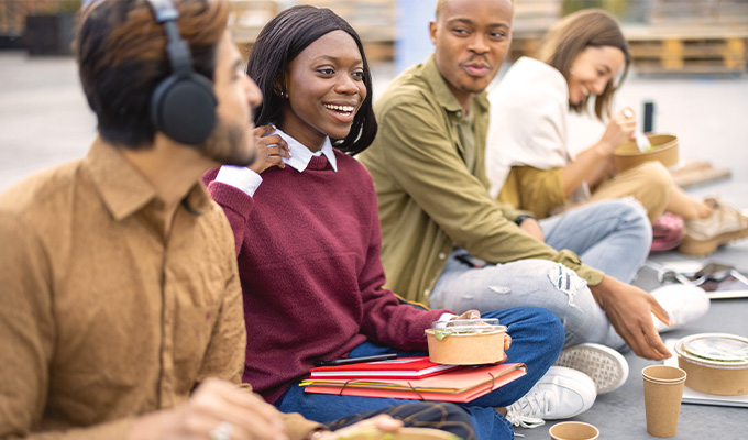 Gruppe von Menschen beim Mittagessen auf Treppenstufen