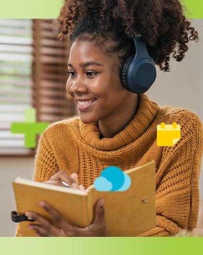 Junge Frau mit Kopfhörern sitzt vor ihrem Laptop und lächelt.